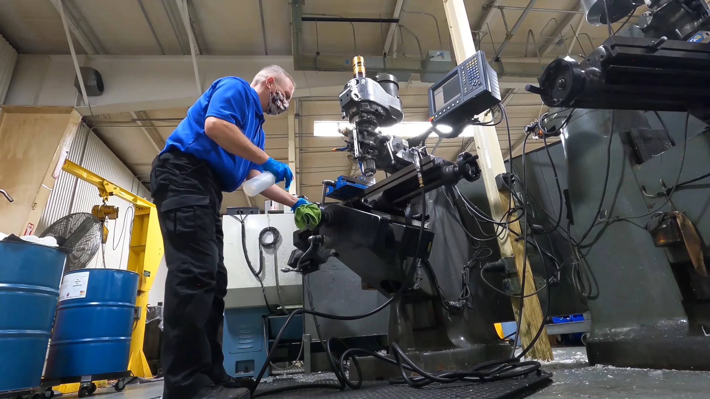 Technician degreasing machinery in a client's shop