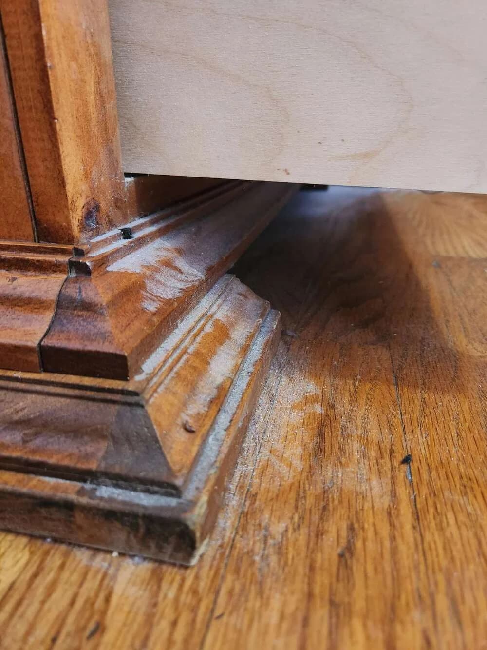 A floor half restored, the hard line between years of grime and finished wood
