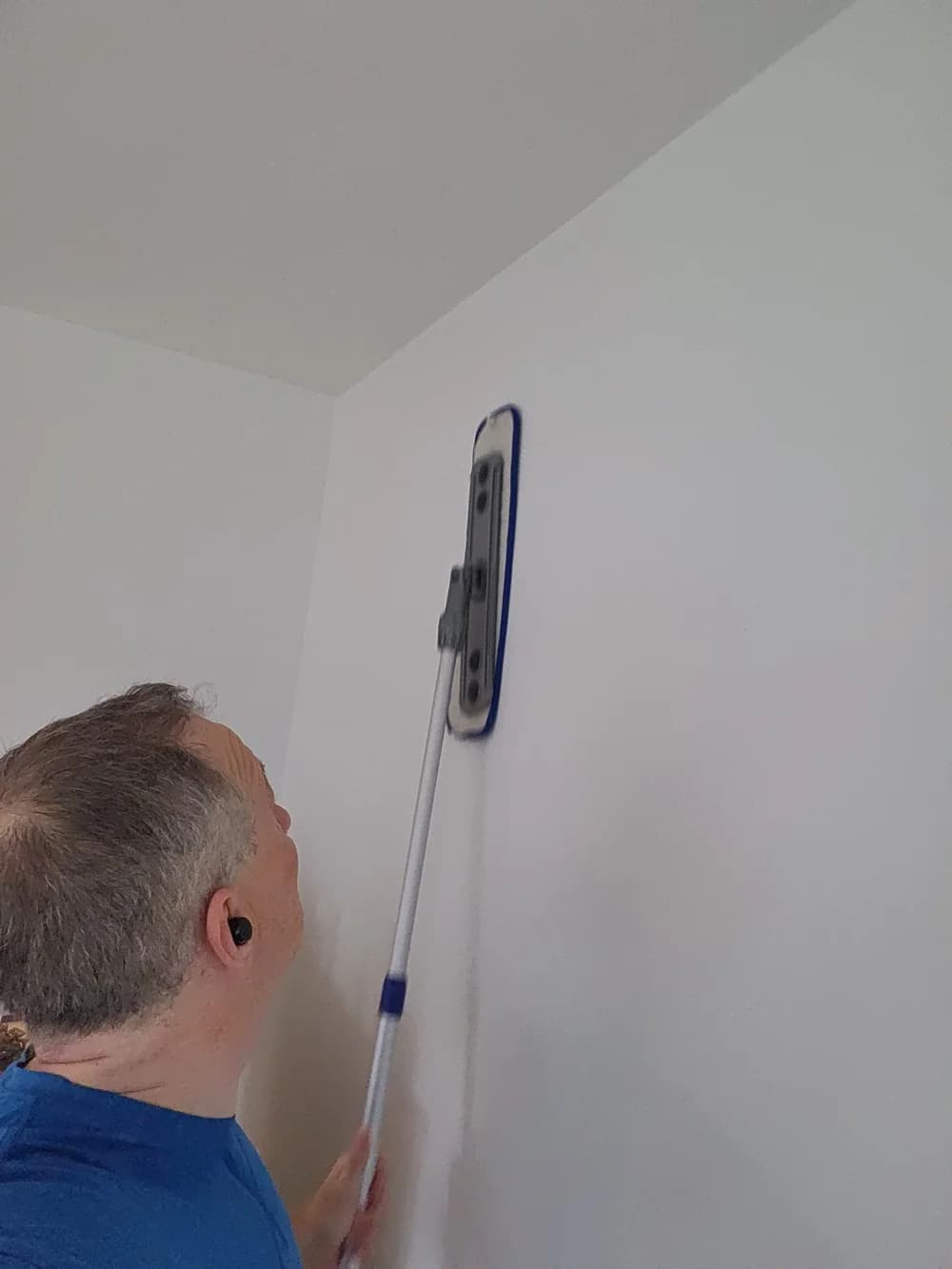 Technician working a wall from ceiling to floor, the standard for sweat-touched surfaces