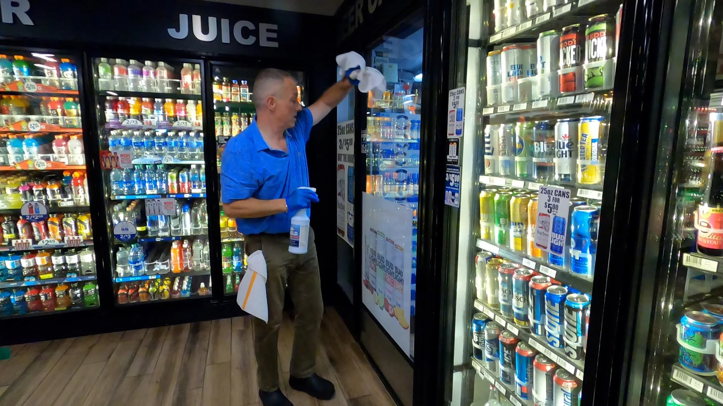 Technician cleaning and facing a retail cooler case