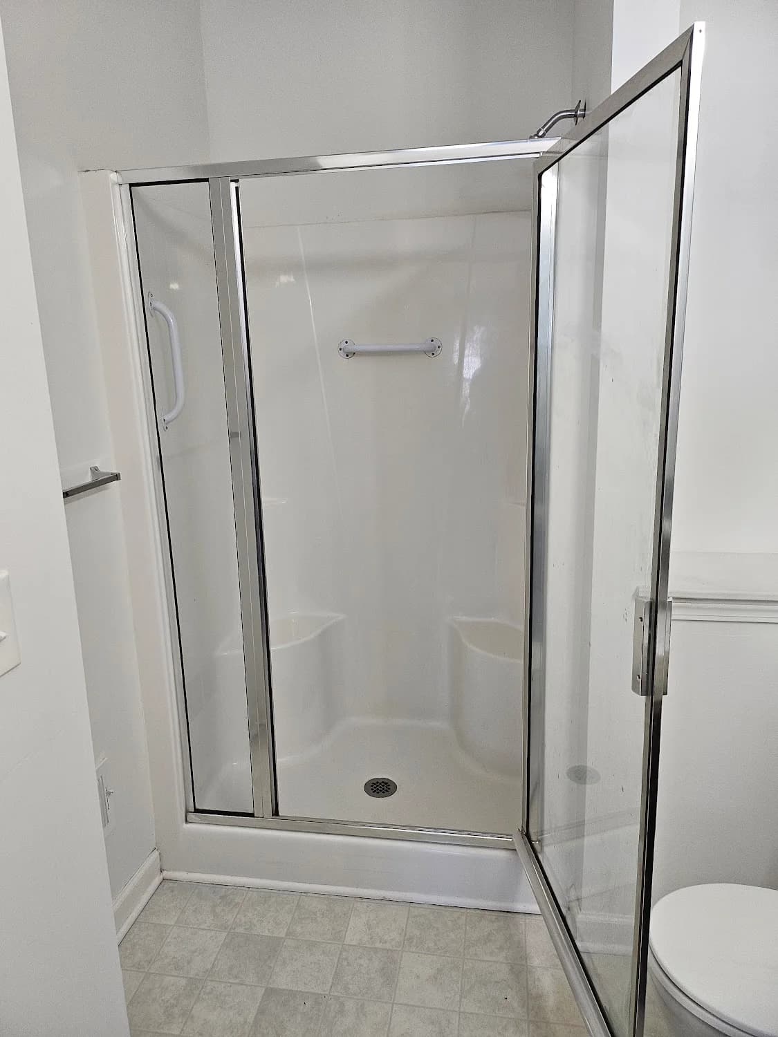 Glass shower door cleaned to streak-free after hard-water removal