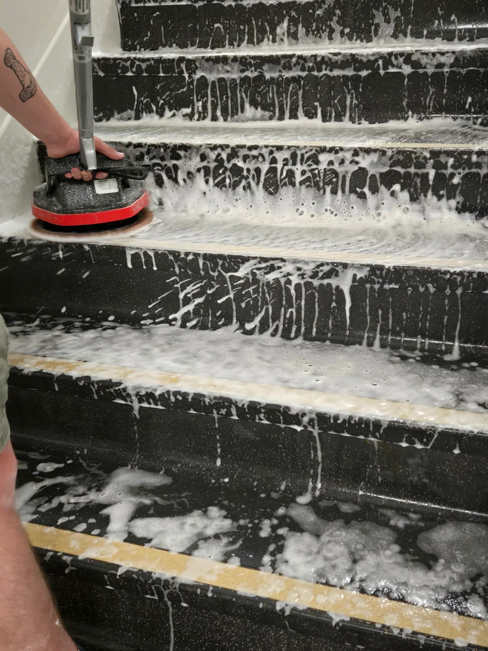 Stair treads under active foam during a stairwell deep clean