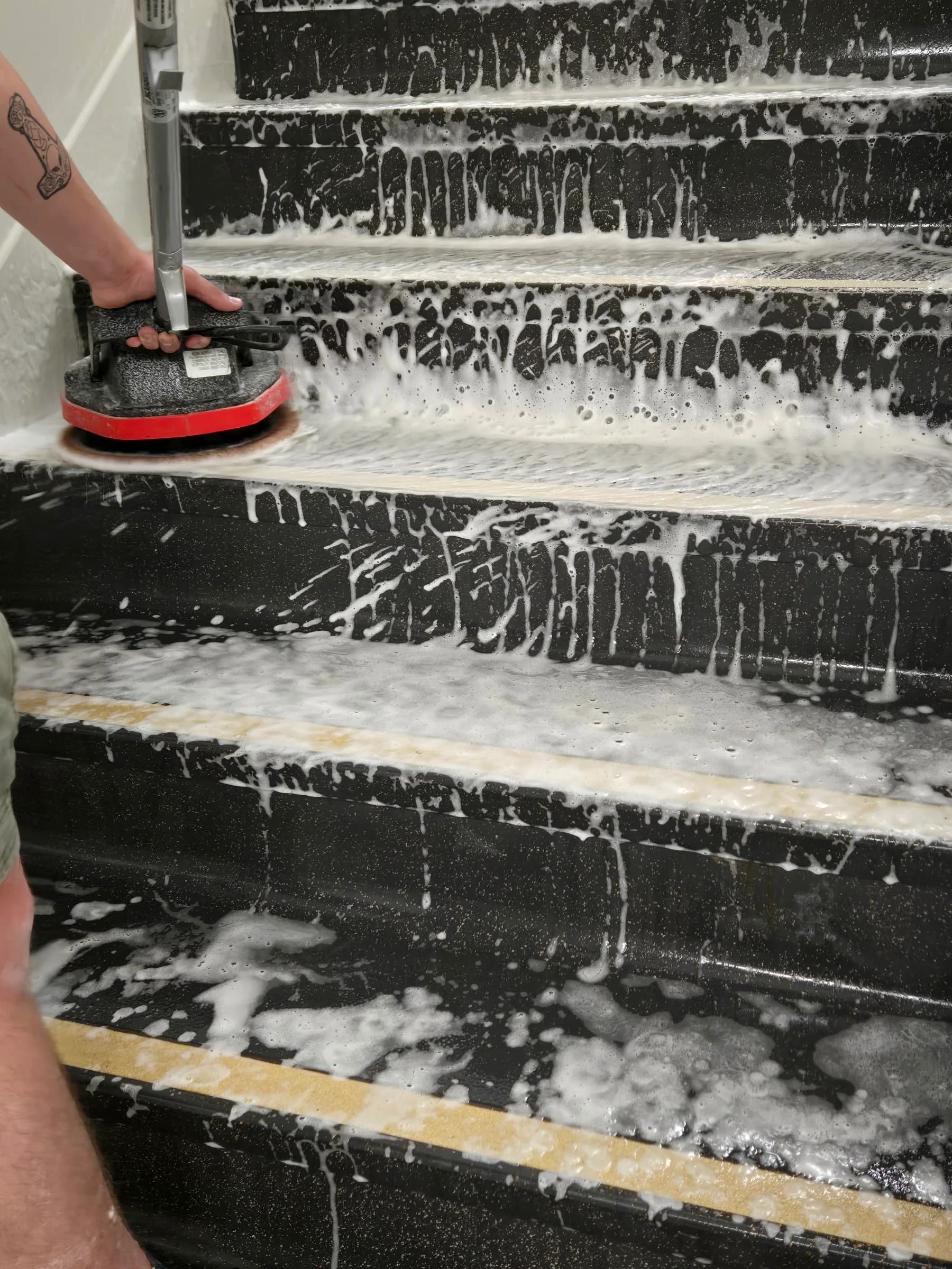 Stair treads under active foam during a stairwell deep clean